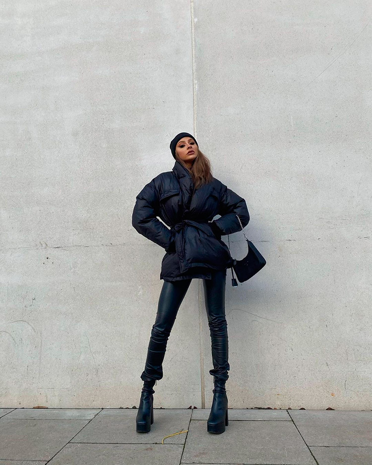 A girl in the streets with a total black look from Misspap: puffy jacket, skinny pants and high boots